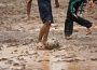 Kids playing football in mud